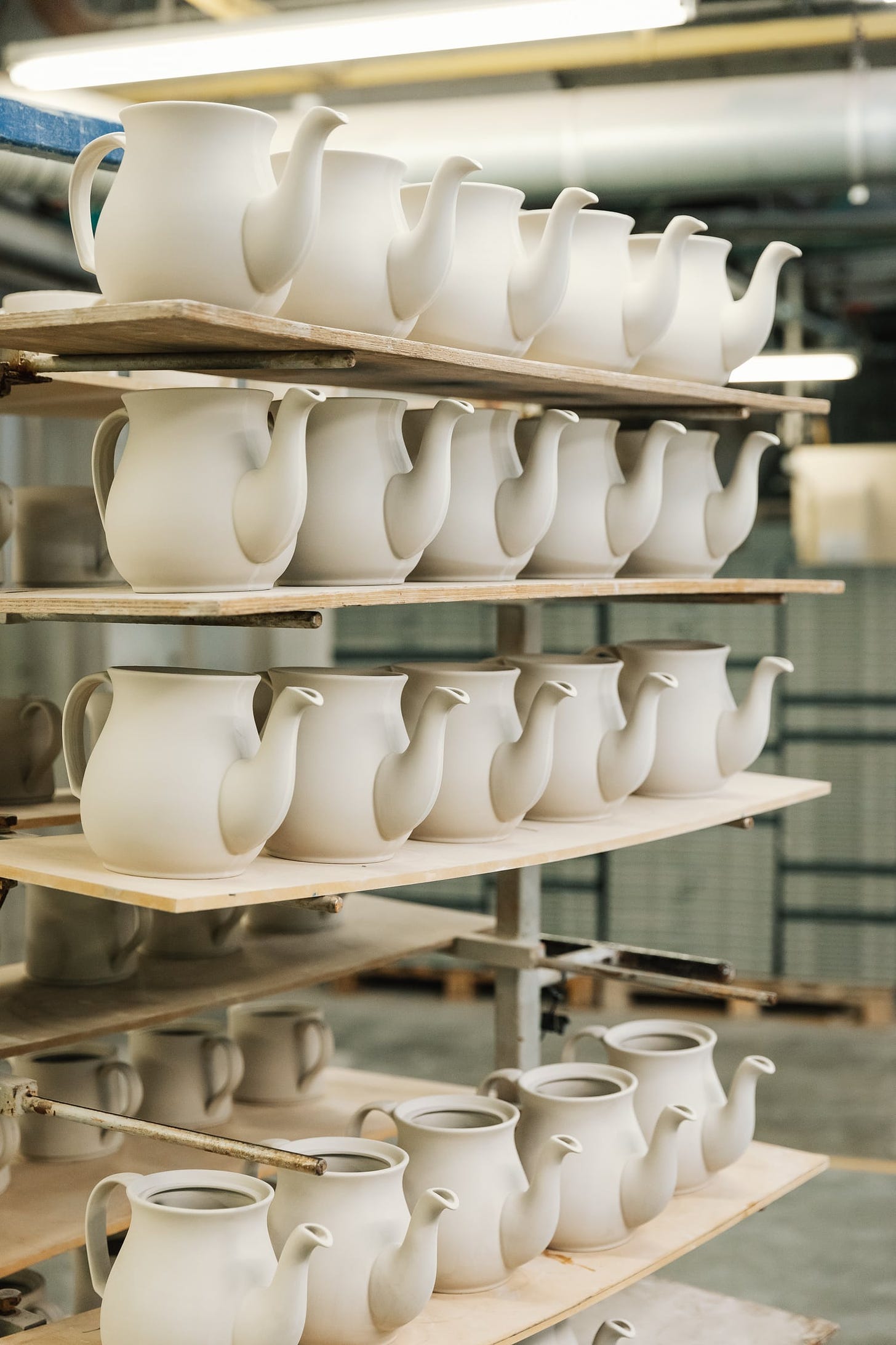 There shelves full of part-made teapots. In a factory. 