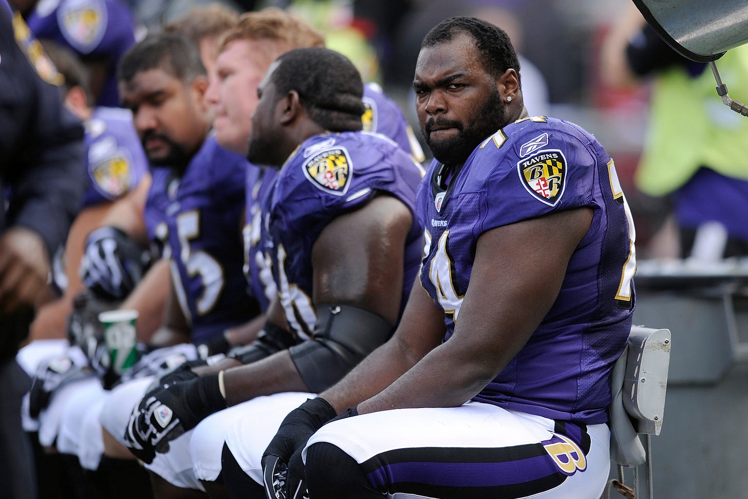 Baltimore Ravens offensive tackle Michael Oher sits on the beach during the first half of an NFL football game against the Buffalo Bills in Baltimore, Sunday, Oct. 24, 2010.