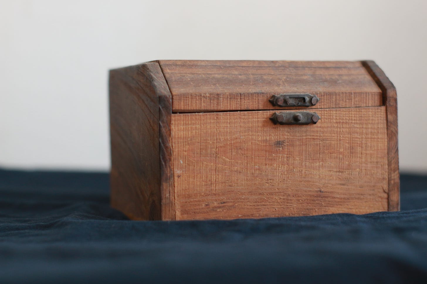 A sturdy-looking wooden box with a catch - the kind you'd keep a secret in.