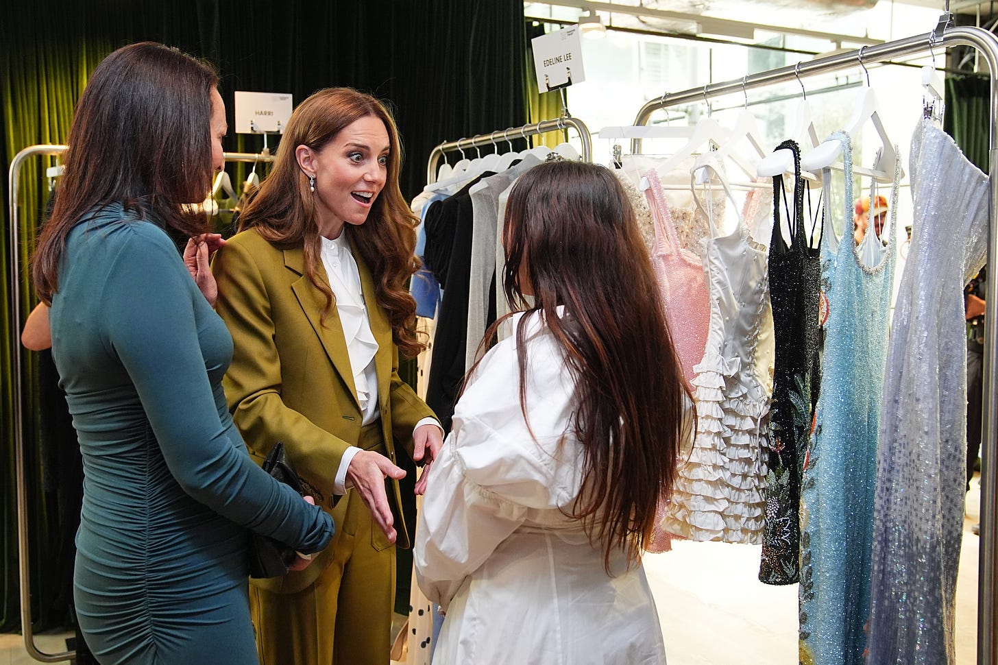 Princess Kate talking to two women amid clothes racks