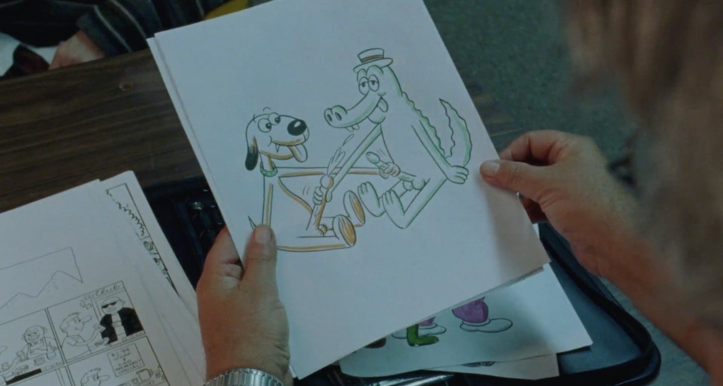 Movie still from Funny Pages. Hands hold up a crude cartoon sketch of a dog and alligator jacking each other off.