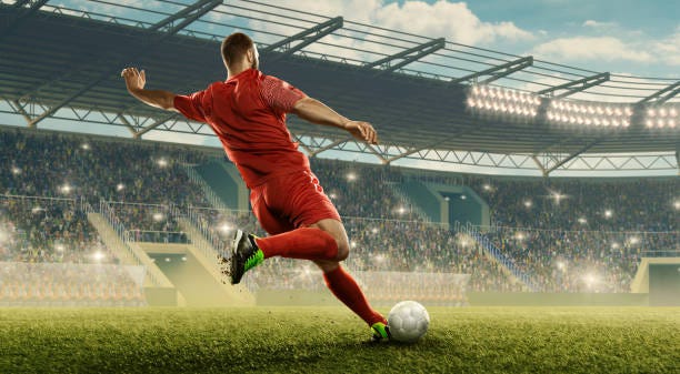 Soccer player kicks a ball Professional soccer player with a ball in action. Soccer stadium with tribunes and fans cheering. Sports event championship game stock pictures, royalty-free photos & images