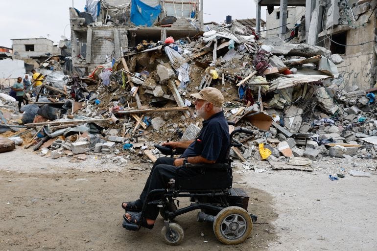 A Palestinian on a wheelchair passes by ruins of buildings destroyed in Israeli attacks, in Rafah in the southern Gaza Strip A Palestinian on a wheelchair passes by ruins of buildings destroyed in Israeli attacks, in Rafah in the southern Gaza Strip