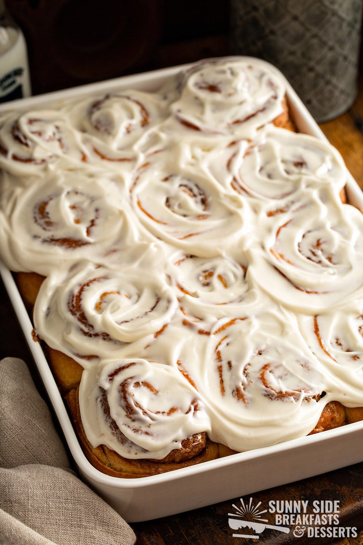 Frosted cinnamon buns in a baking dish.