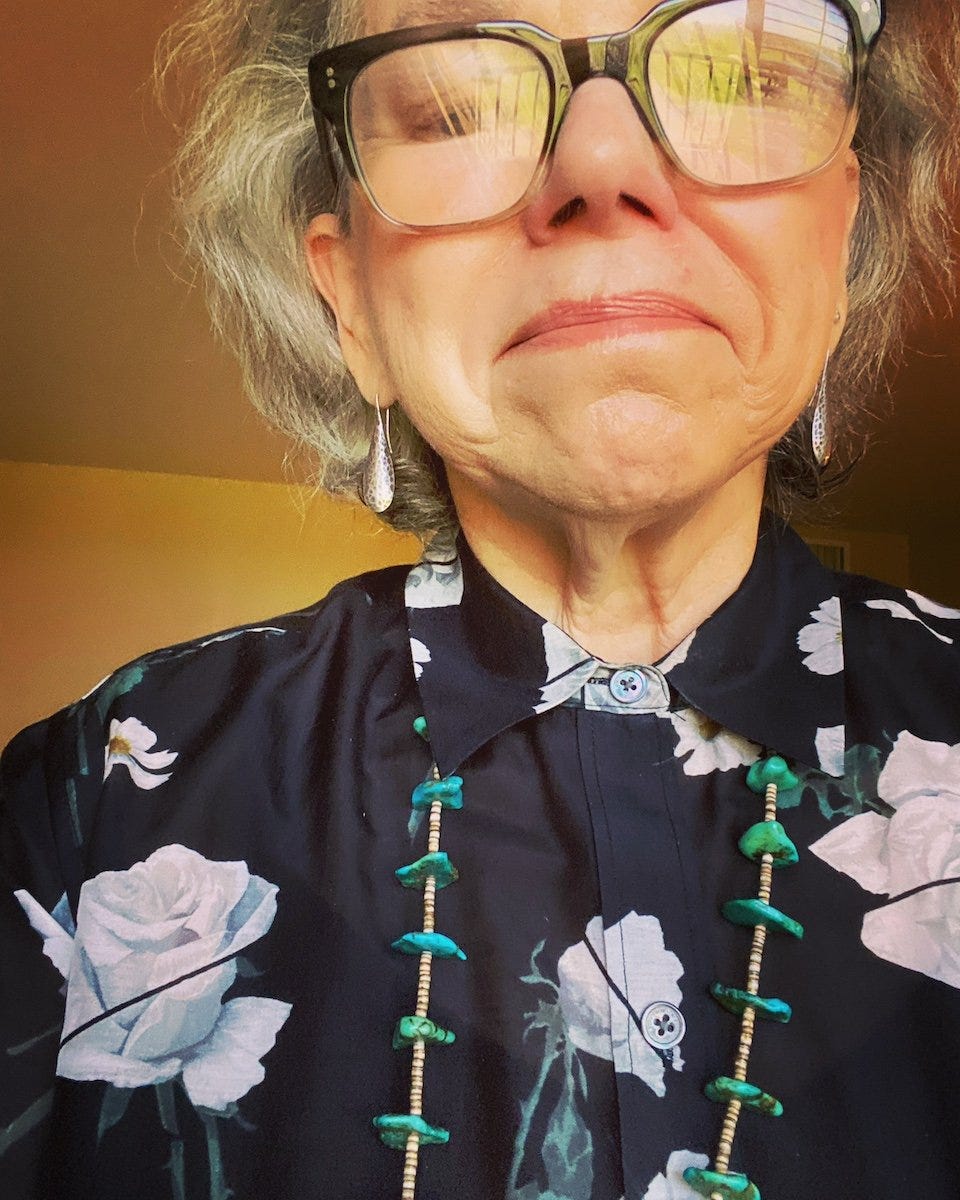 a woman wearing glasses and a floral shirt