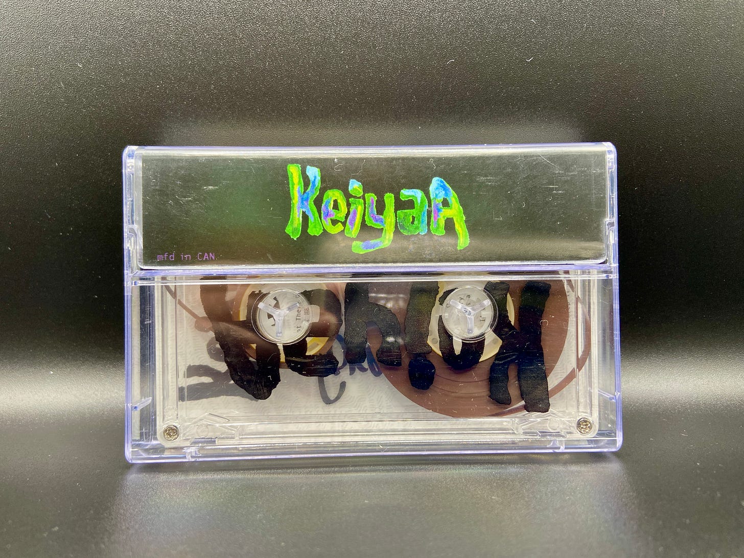 the back view of the Forever, Ya Girl cassette in its case, with keiyaA’s name written in blue and green.