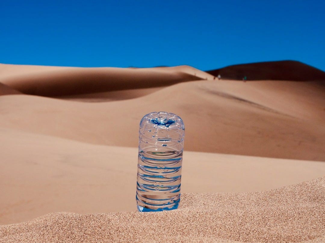 clear plastic bottle on brown sand