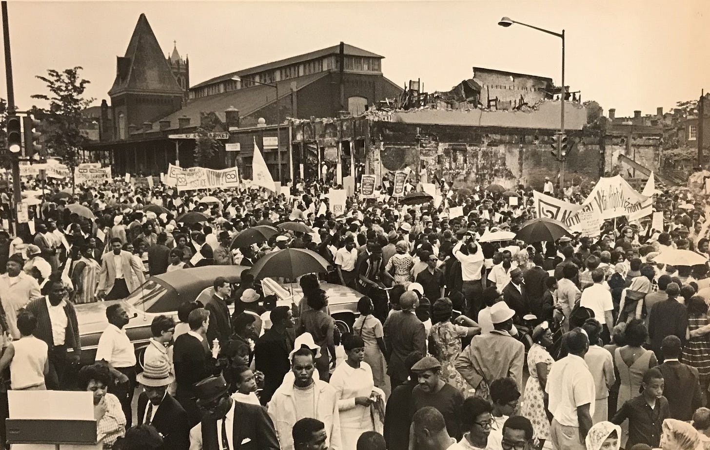 A sepia-toned photograph of a large crowd in DC.