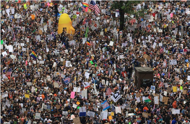 A large crowd of people holding signs with Bubblegum Alley in the background

AI-generated content may be incorrect.