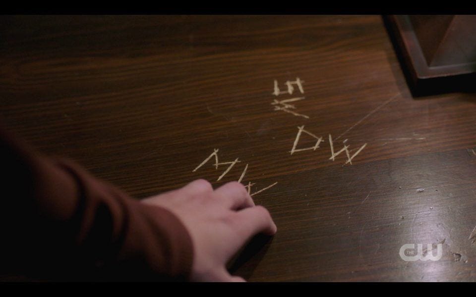 Jack touching Mary Winchester initials scratched into table SPN 1512