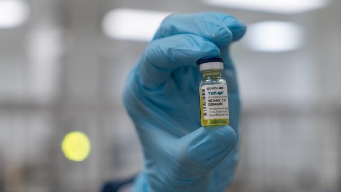 A gloved hand holding a vial of Yeztugo, a lenacapavir injection for HIV prevention.