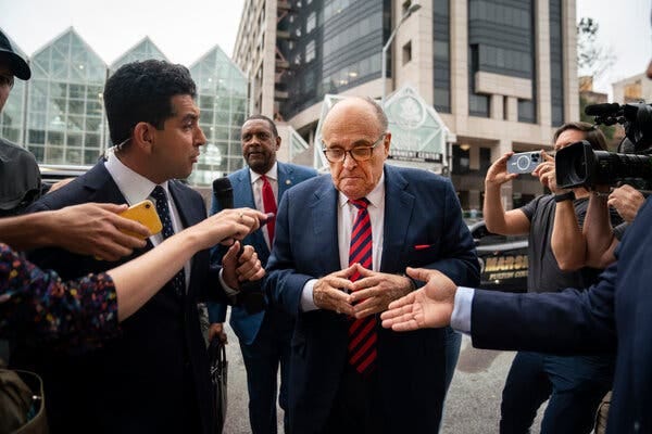 Rudolph W. Giuliani, in a suit and tie, is surrounded by reporters as he arrives at court in Atlanta.