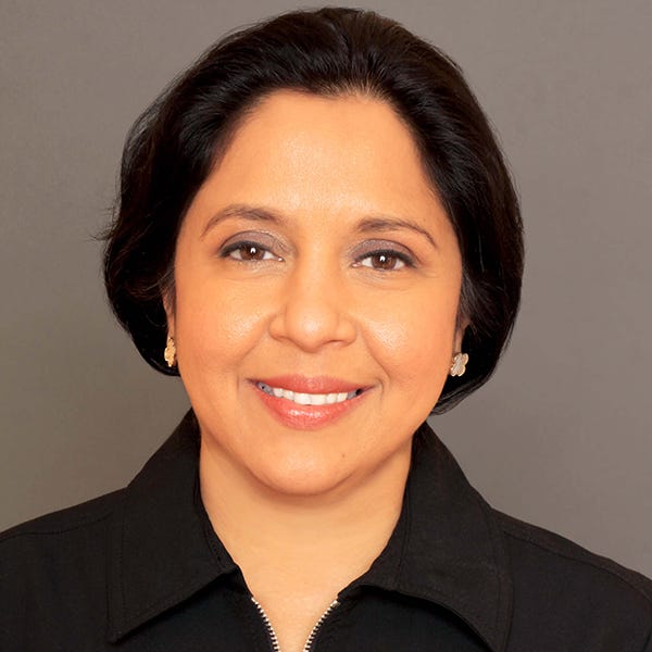 Woman with dark hair pulled back smiling at the camera