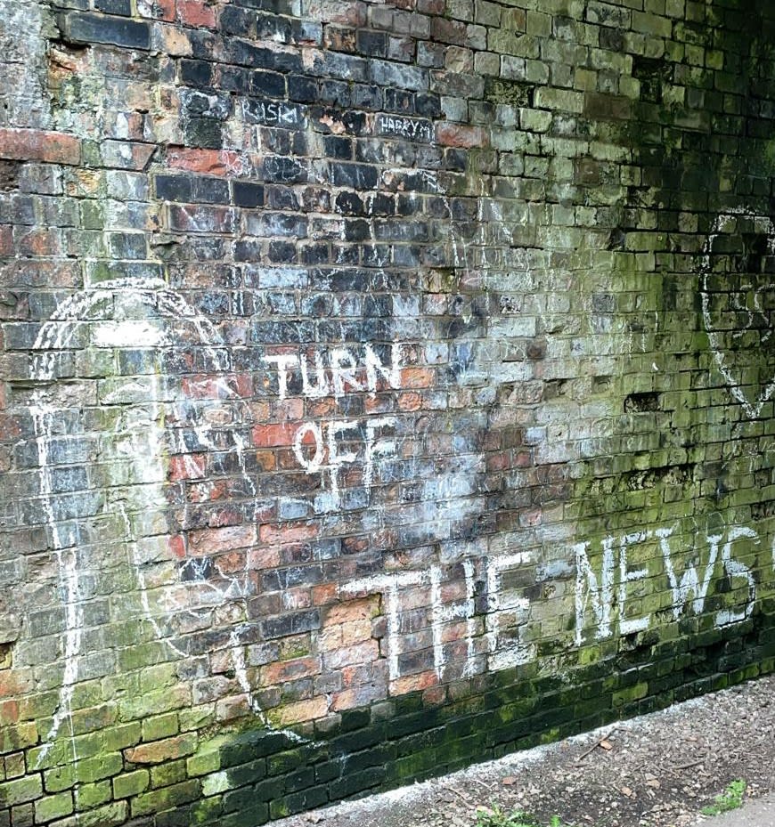 Dirty brick tunnel wall with graffiti Turn Off The News