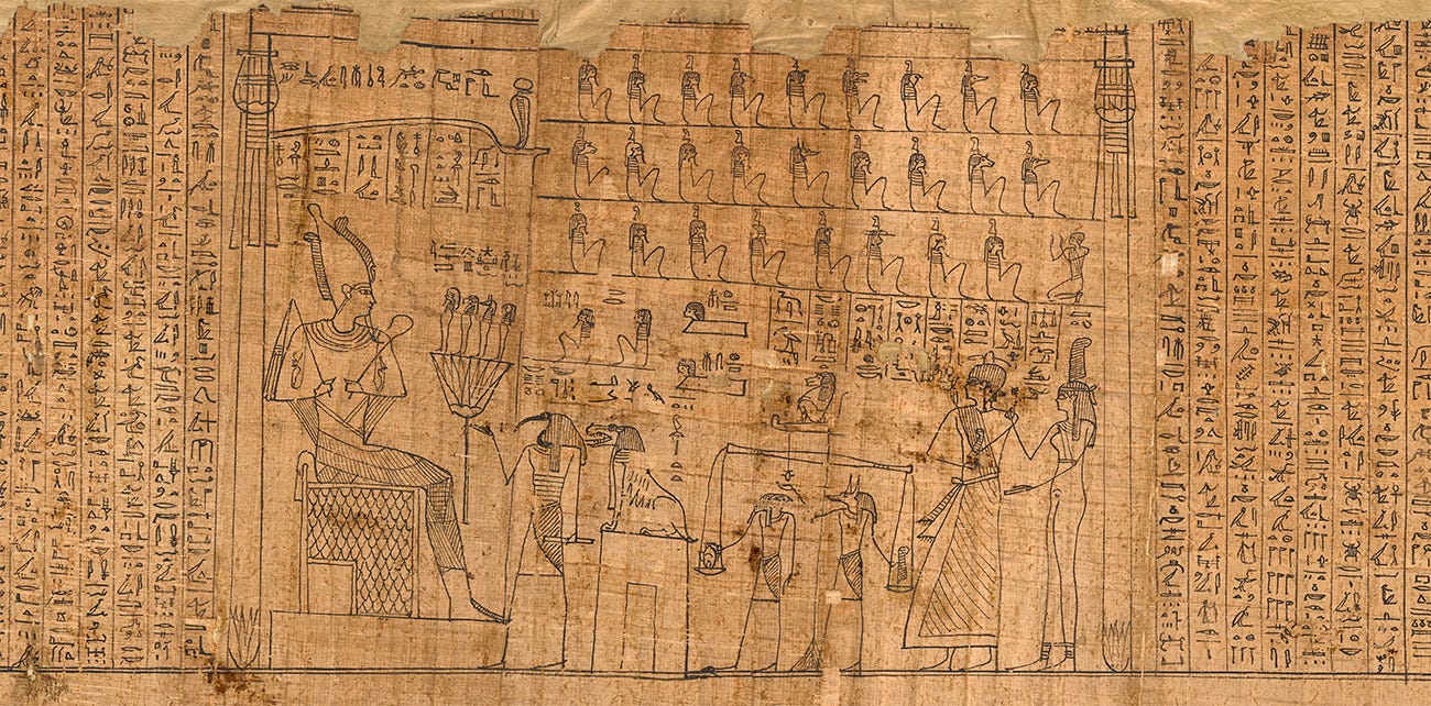 Close-up detail of hieroglyphics and drawings that depict the Osiris and a tribunal of gods, written on a piece of papyrus