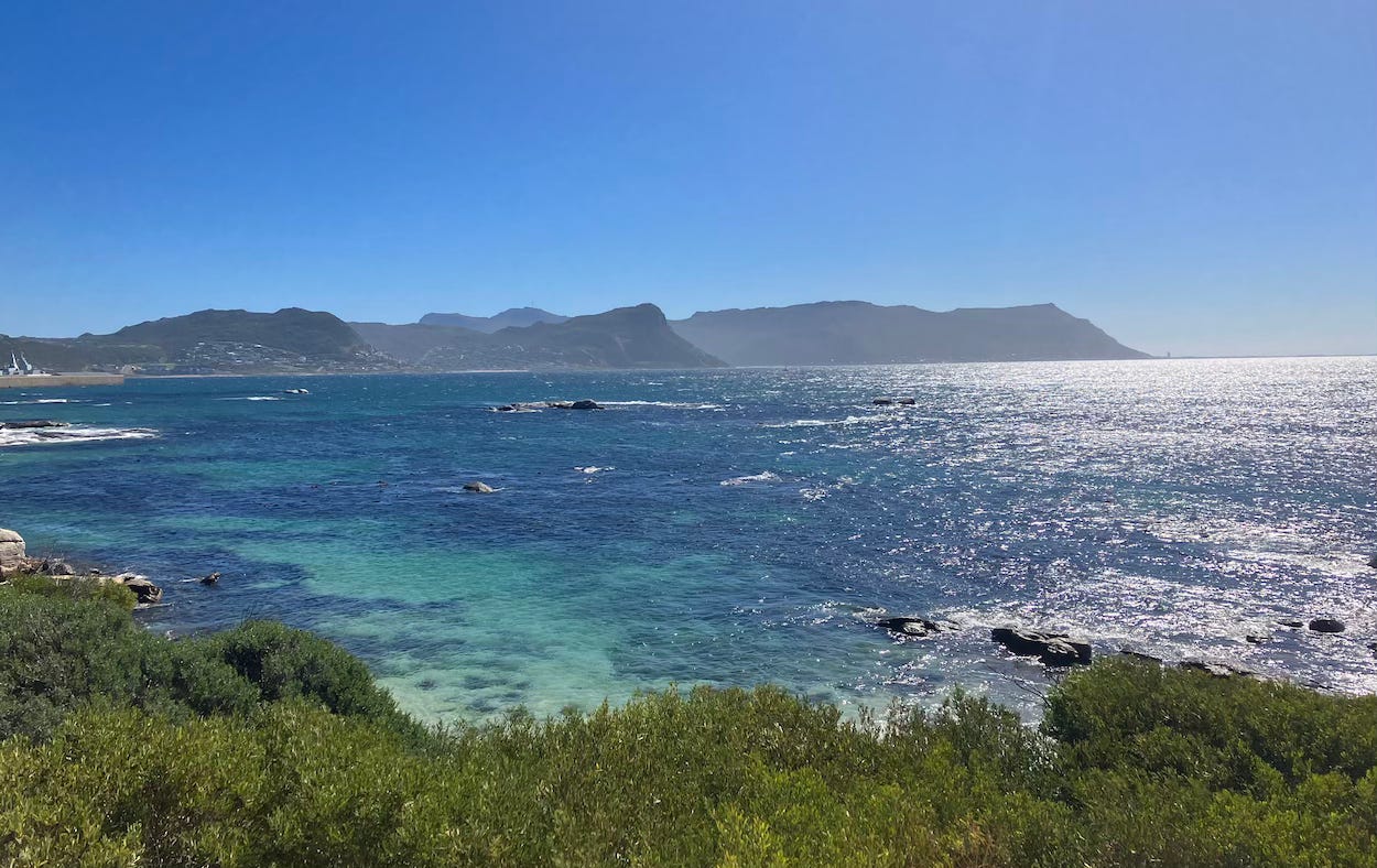 Blue skies on a warm day over a sea view with hills behind