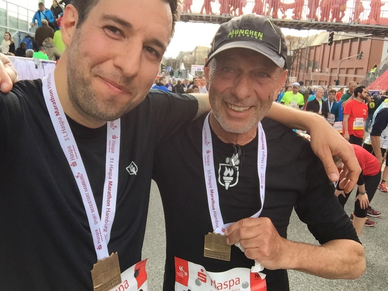 The author and his father at the finish line of the Hamburg Marathon, holding their medals in the camera