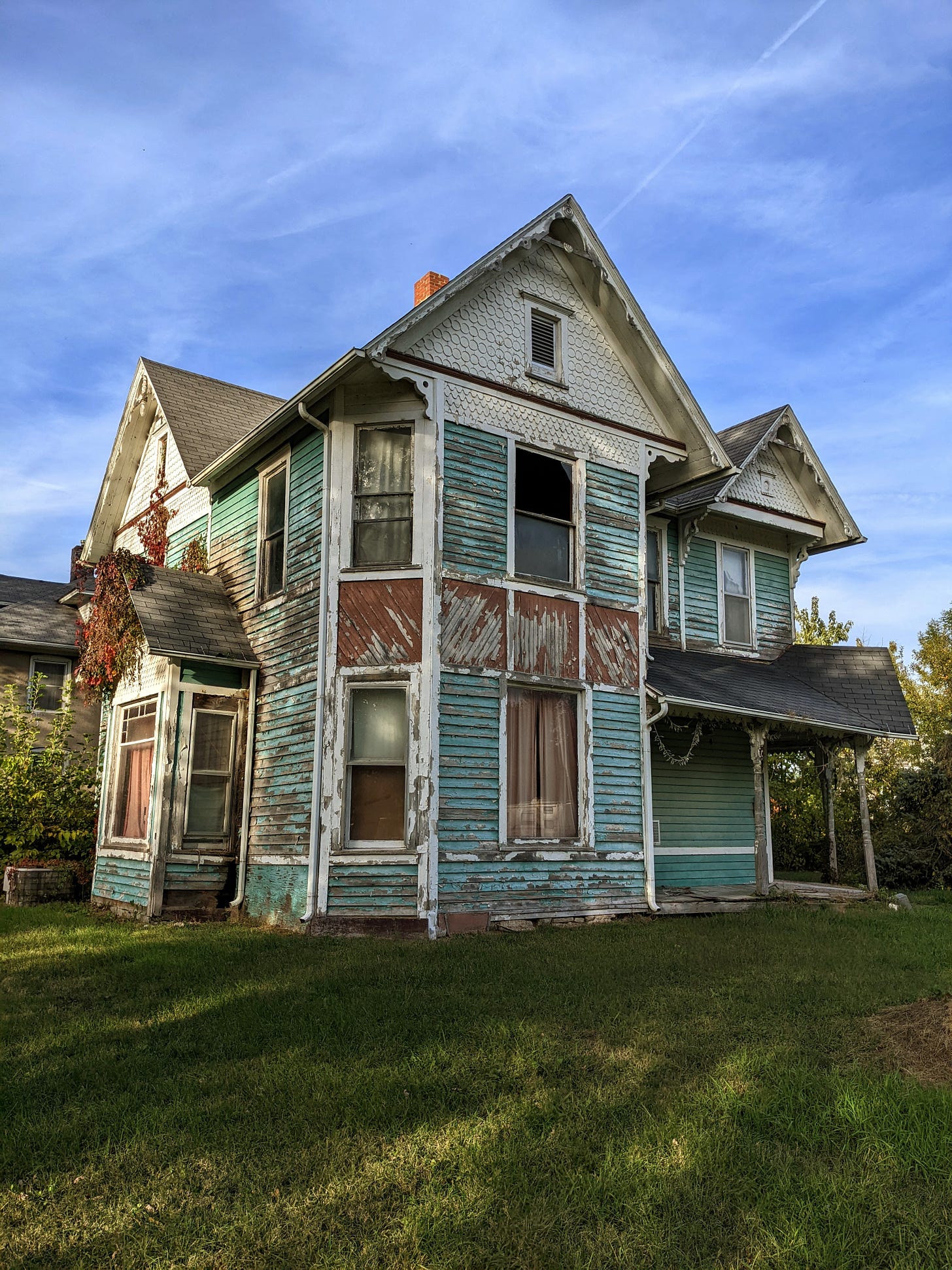 an abandoned two-story house, in classic Queen Anne style