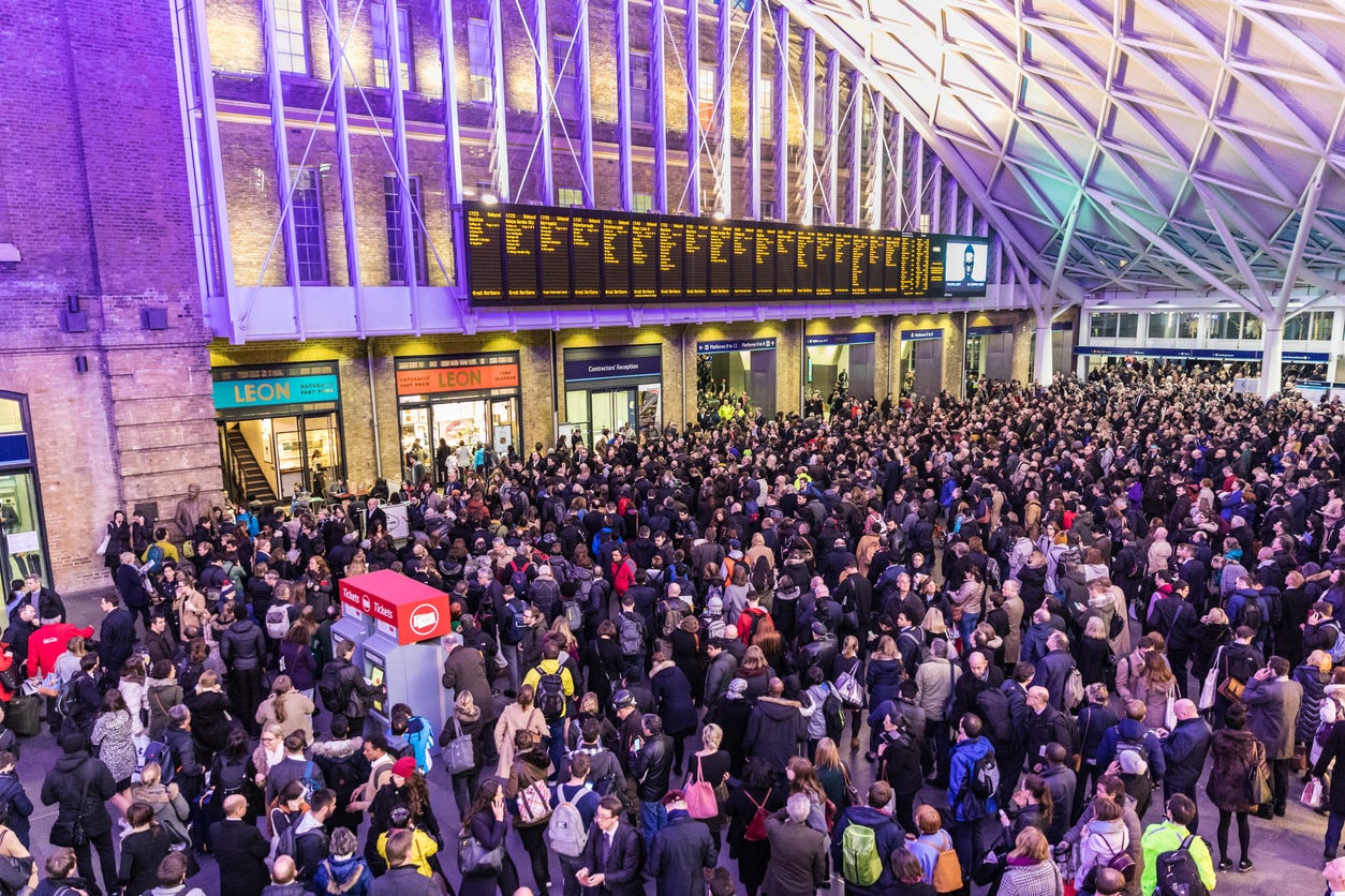 Crowded Kings Cross station in London. Hundreds people waiting for the train.