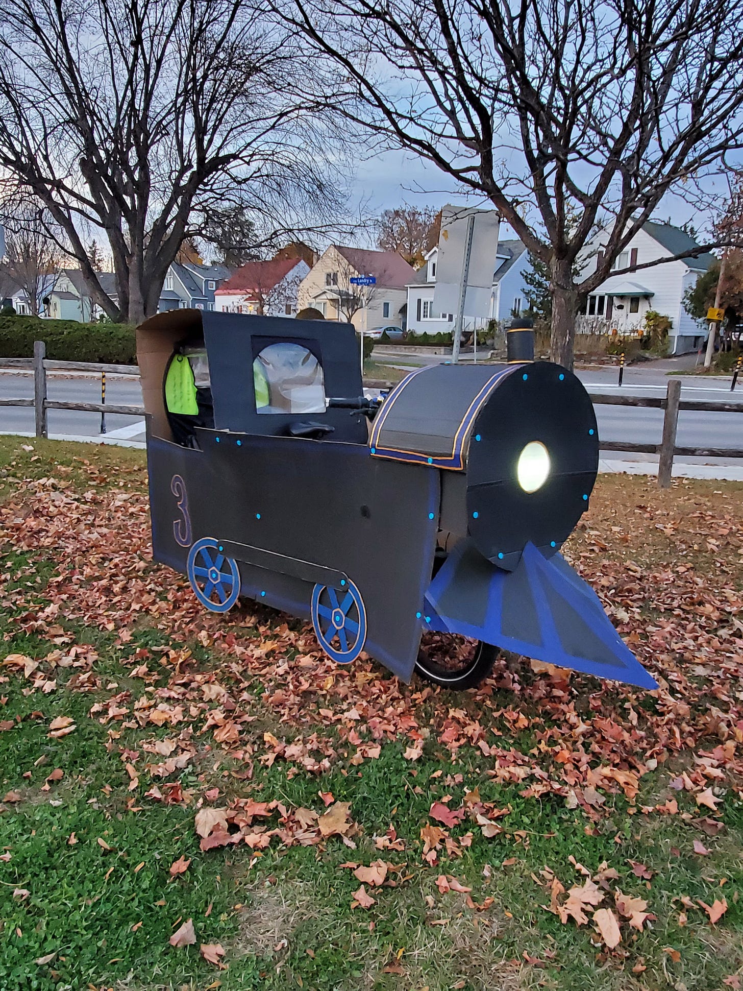 A photo of a Tern GSD e-cargo bike with a cardboard train costume exterior. The train cabin covers the rider seat in the back, and the headlight comes out a barrel on the front.