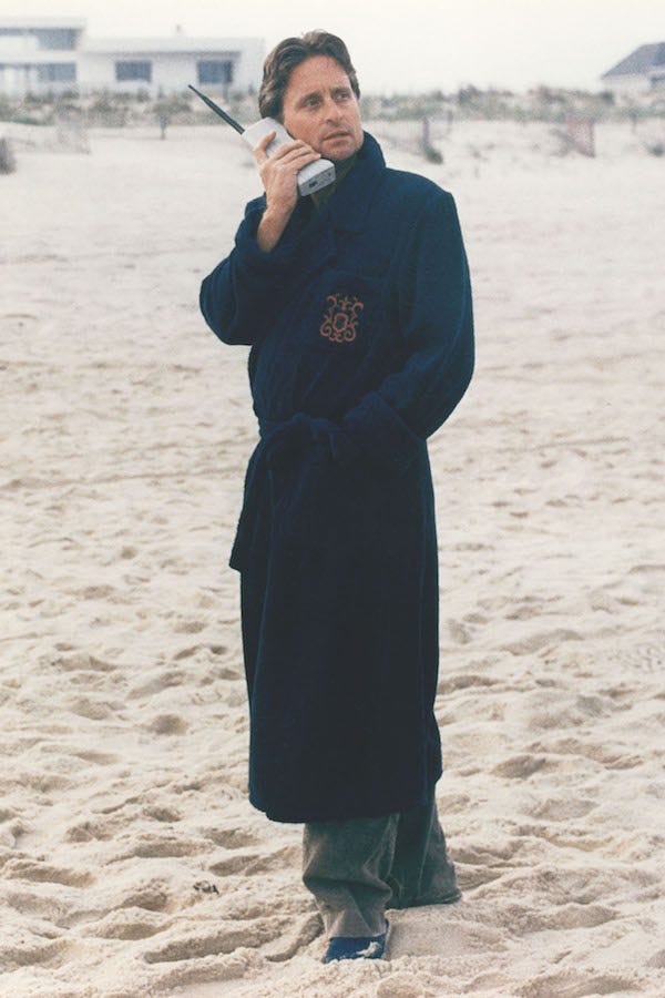Gekko takes a business call wearing his crest-engraved dressing gown over a grey suit outside his beach house. Photograph by 20th Century Fox/Kobal/REX/Shutterstock.