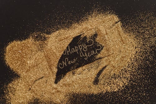 Free A festive greeting with glitter and cursive lettering spelling 'Happy New Year'. Perfect for seasonal celebrations. Stock Photo