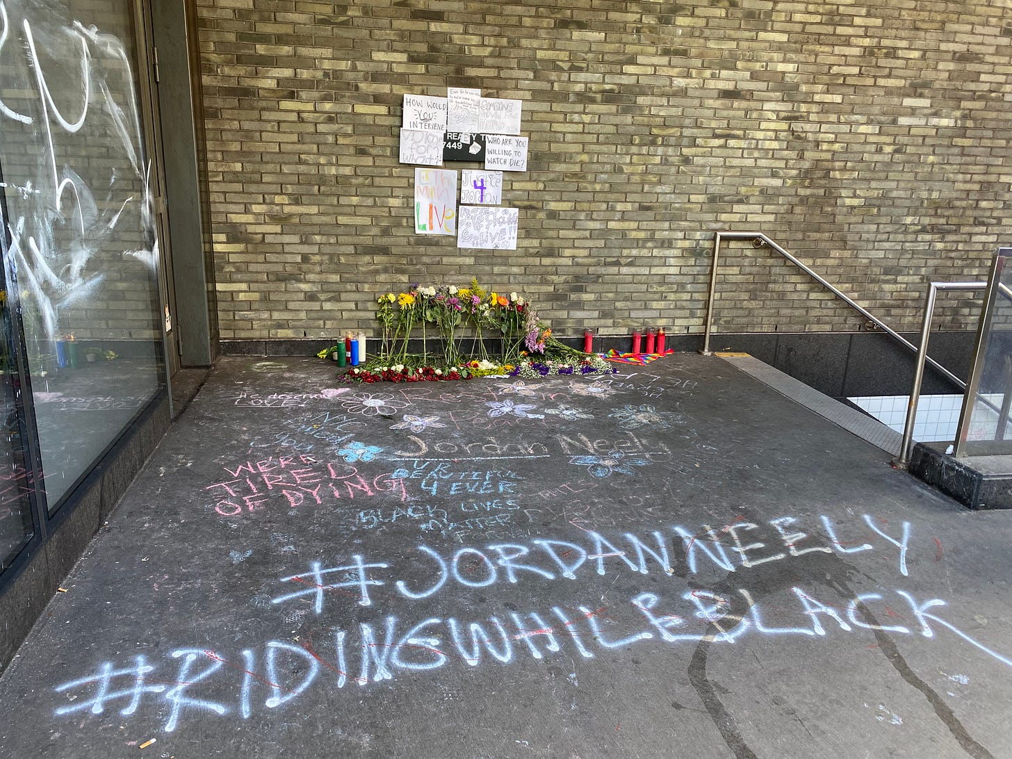 Flowers by the subway entrance where Jordan Neely died.