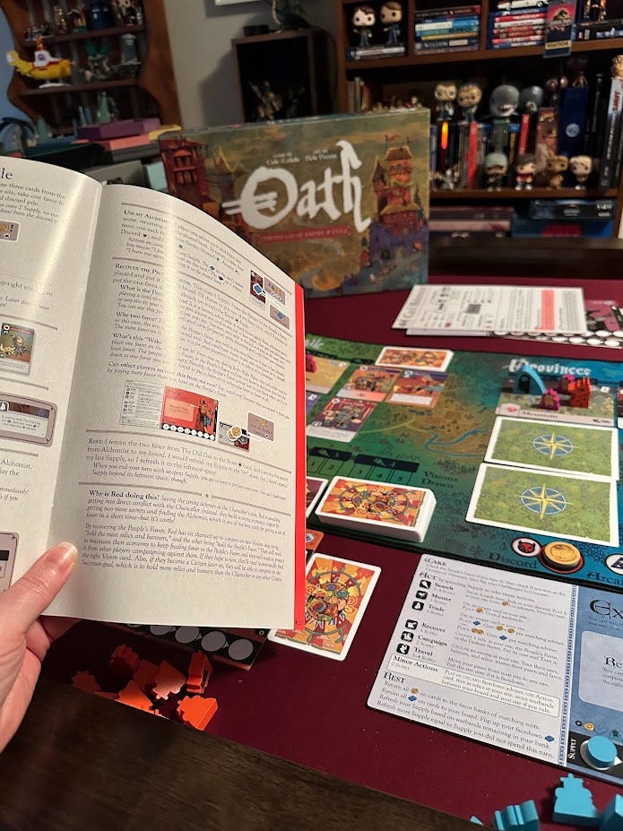 photo hand holding rule book and board game in background