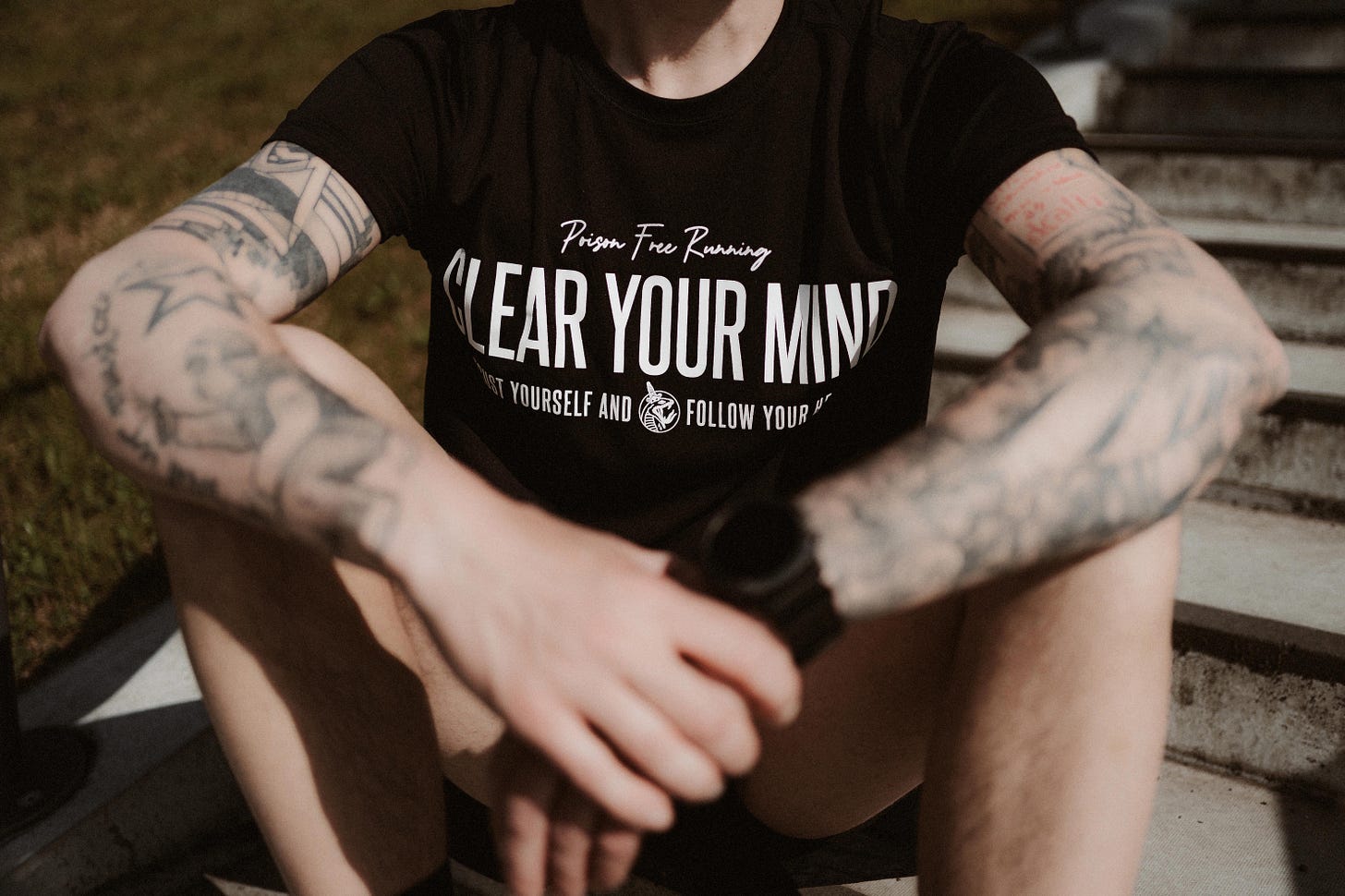 Tattooed runner with a shirt saying "clear your mind"