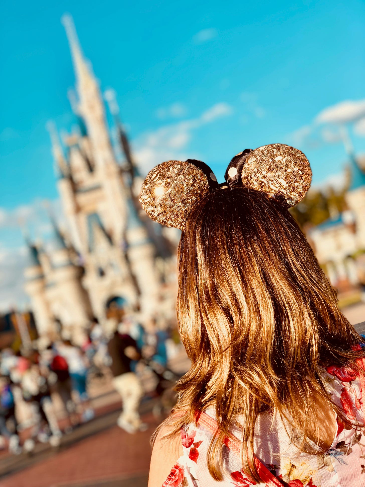 Woman wearing golden Mickey ears at Disney