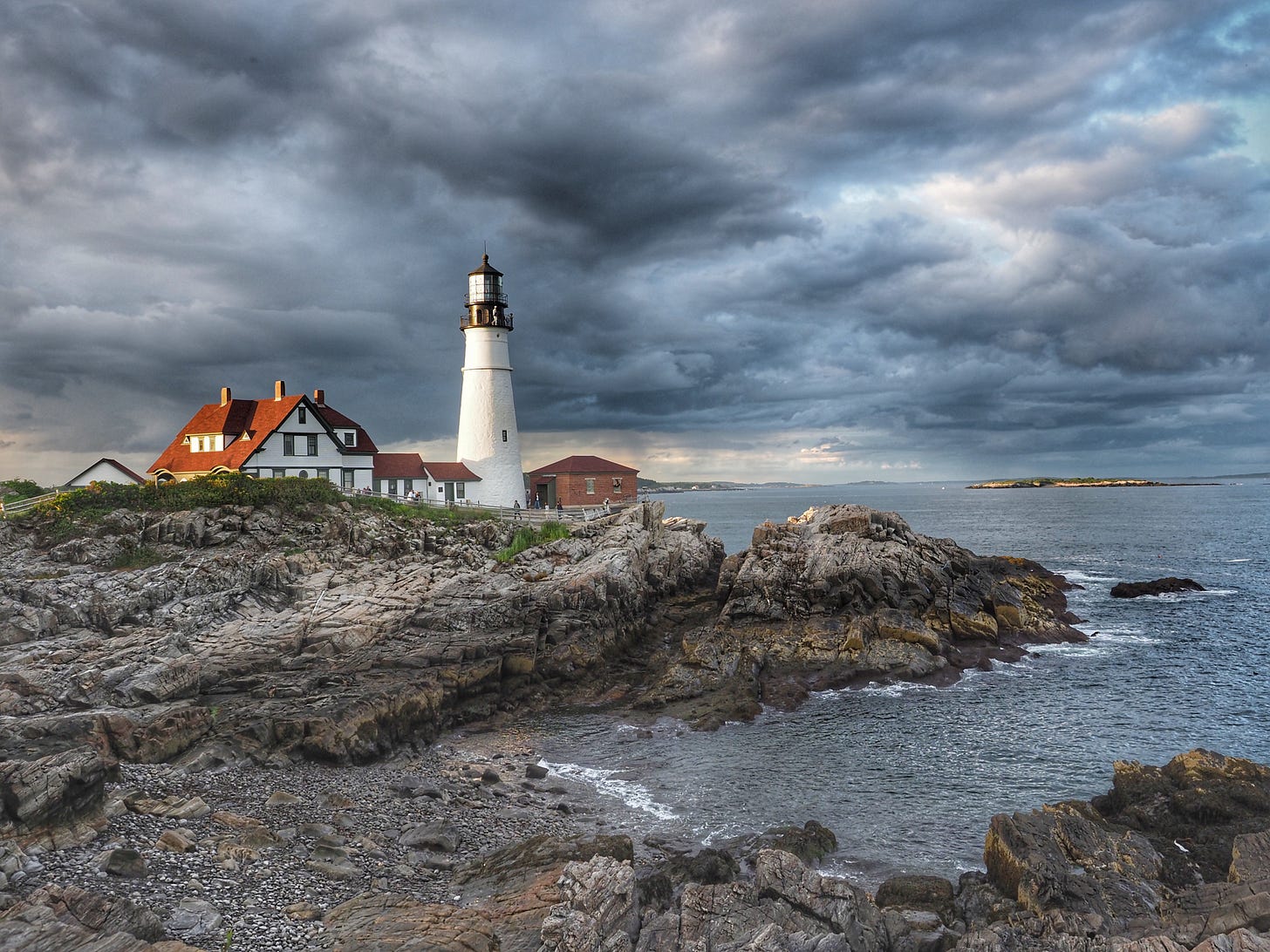 Lighthouse on a cliff by the ocean on a stormy day