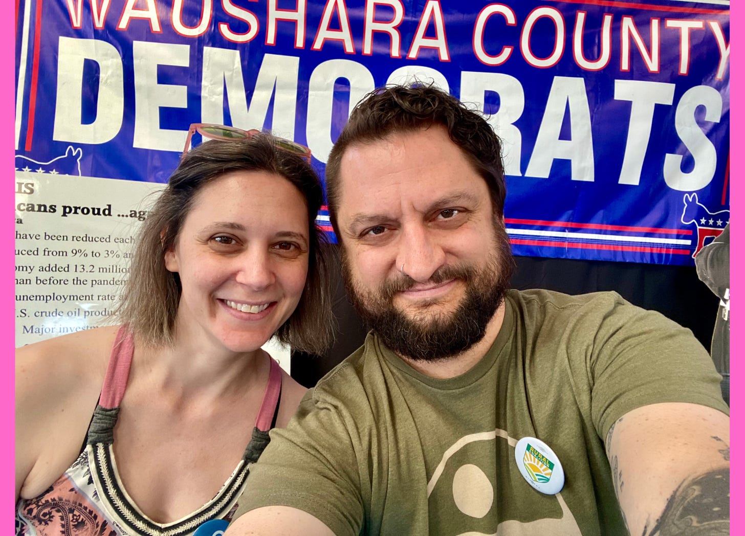 Photo of a couple in front of a "democrats" sign