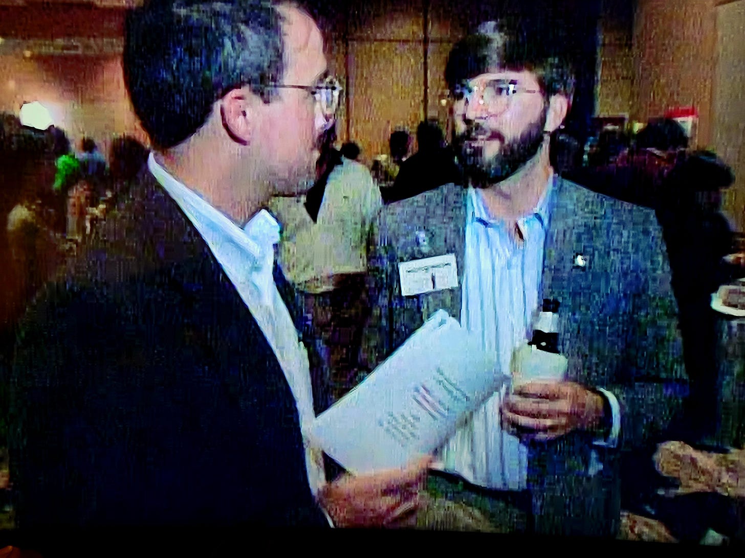 My "devil's advocate," Juan Garcia (left) and myself in a scene from the documentary, "Beyond JFK," directed by Barbara Kopple & Danny Schechter, shot at the opening reception of The Assassination Symposium on John F. Kennedy, Hyatt Reunion Hotel, Dallas, 1991.