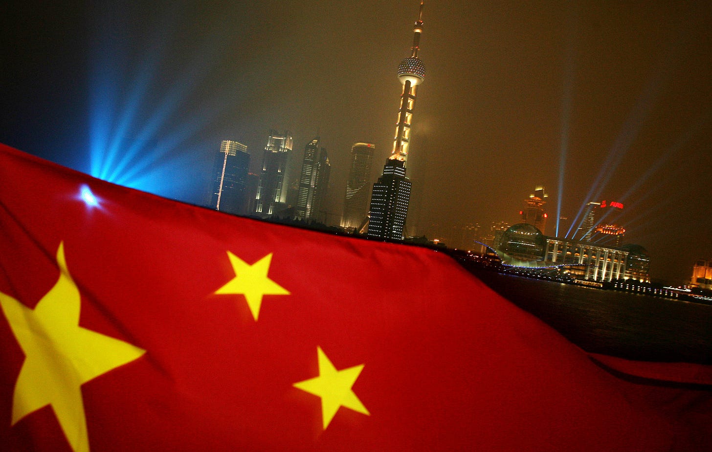 The Chinese flag flies in front of the Shanghai skyline.