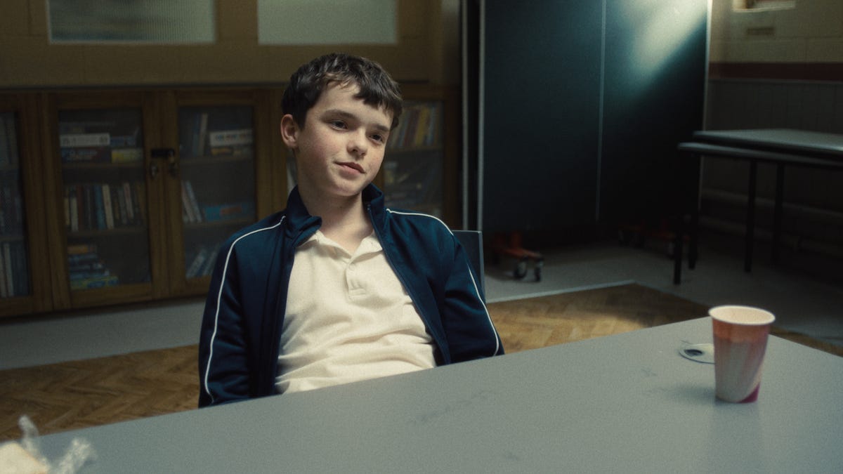 Jamie Miller gazes softly ahead with a quiet, almost childlike expression—his demeanor calm and composed in a moment that contrasts with the violence later revealed in Netflix’s Adolescence.