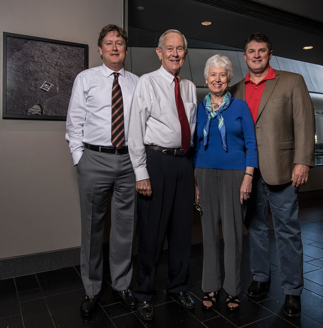 A color, contemporary family photo: older man and woman, two middle aged men.