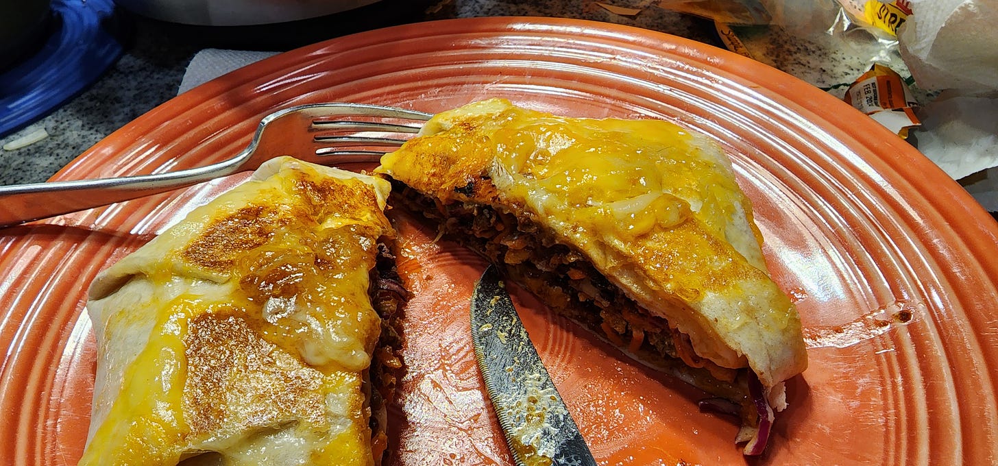 homemade beef gorditas, cut in half on an orange fiestaware plate.