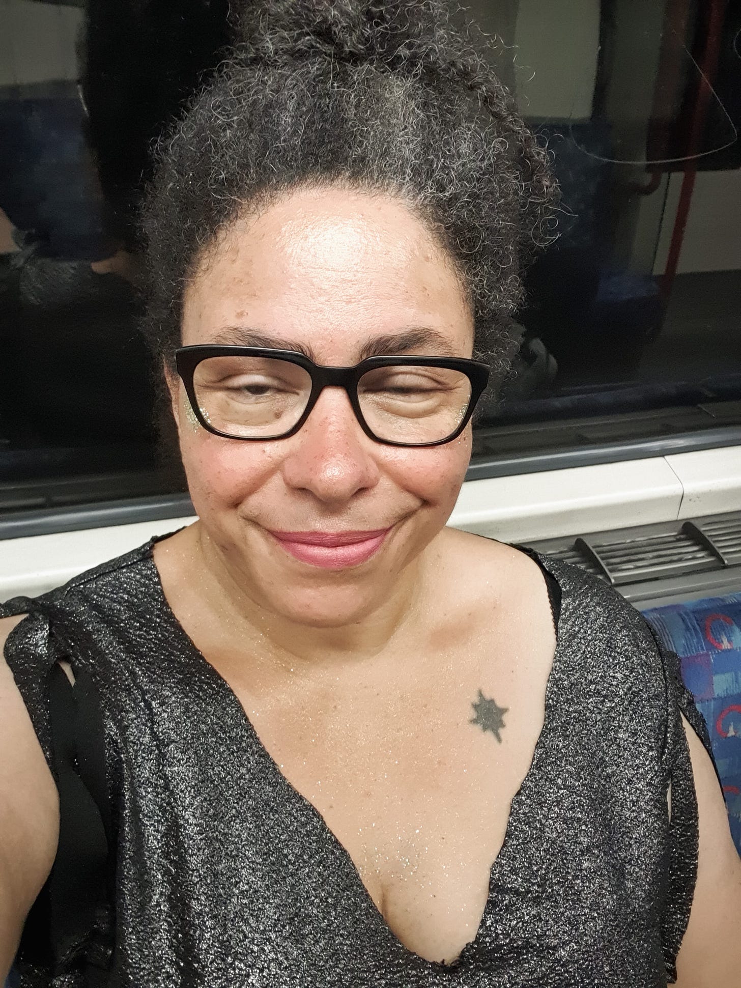 Photo of a woman wearing a silver t-shirt looking worse for wear