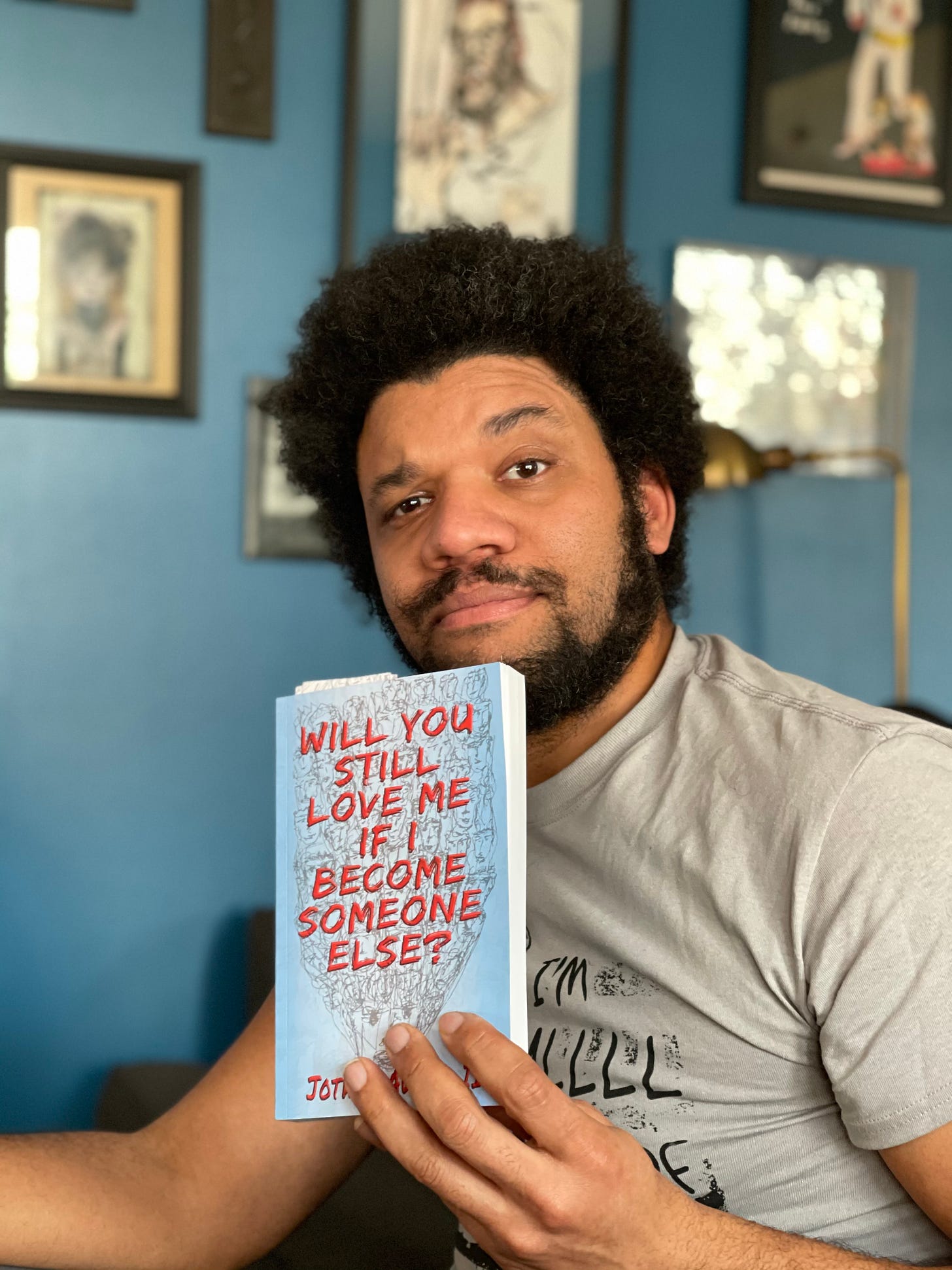 Picture of Jotham Holding his debut novel, ‘Will You Still Love Me If I Become Someone Else?’
