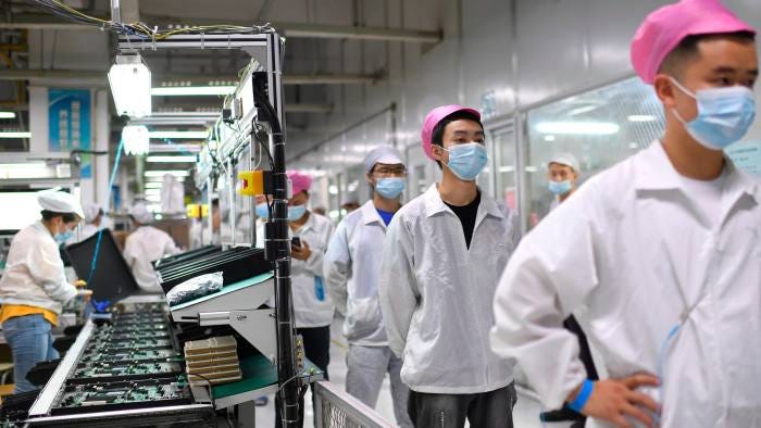 Workers line up to get tested for Covid-19 at the Foxconn factory in Wuhan