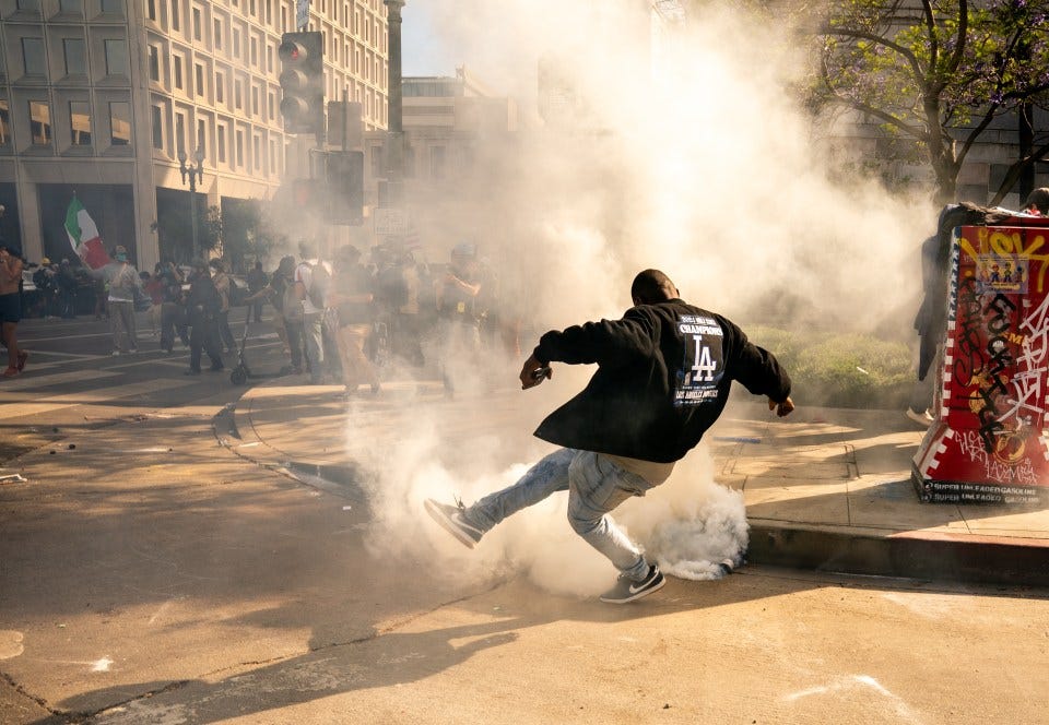 Protestor kicking a gas can during a demonstration.