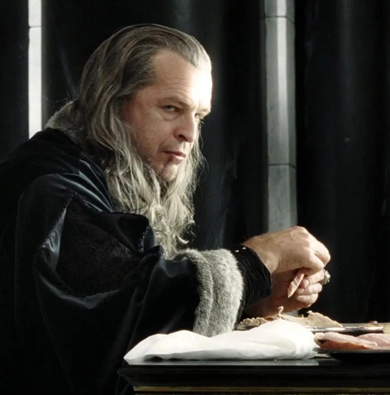 an image of denethor sitting in the White Tower, blood dripping down his chin, glaring at Pippin who is outside the frame.