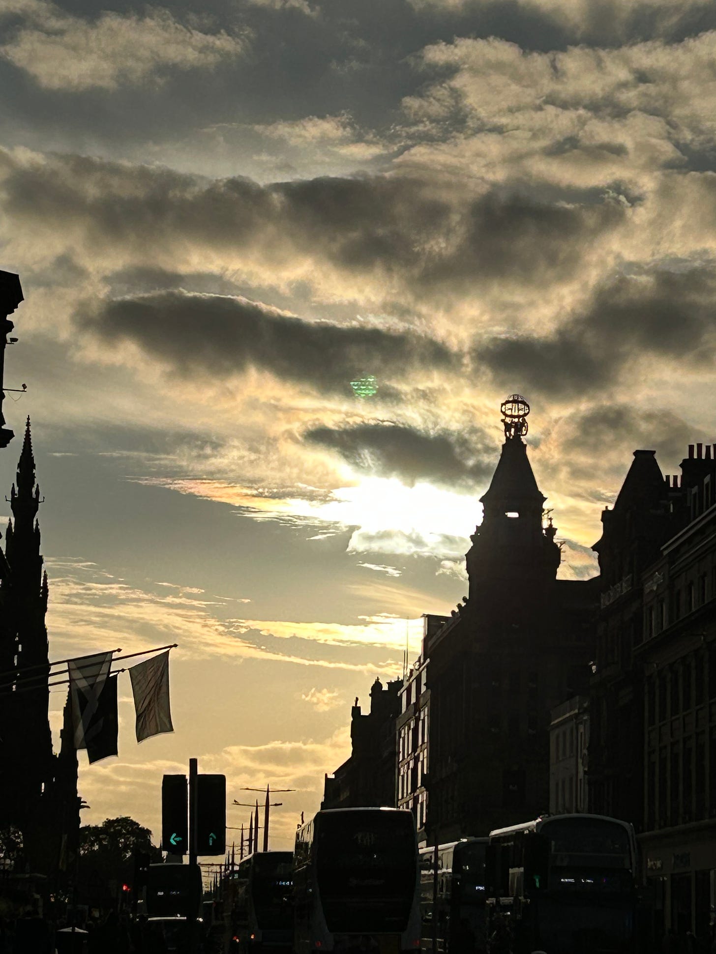 The dark shapes of Edinburgh buildings silhouetted against the setting sun.