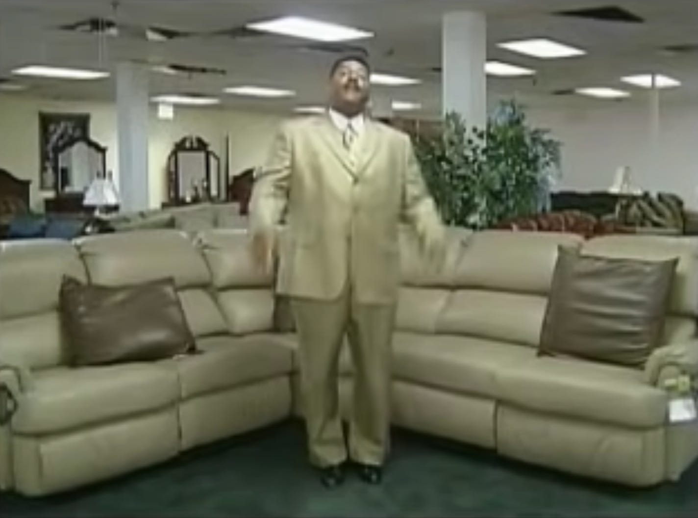 video still from a furniture store commercial with salesperson standing in showroom