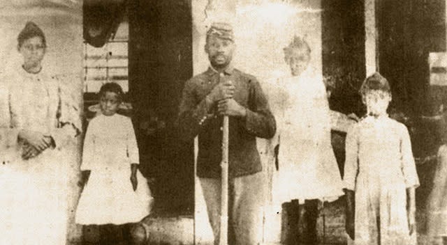 Photo of five African Americans one in the middle in a Union army uniform