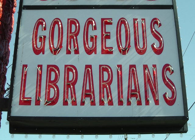 An unlit neon sign that says "Gorgeous Librarians"