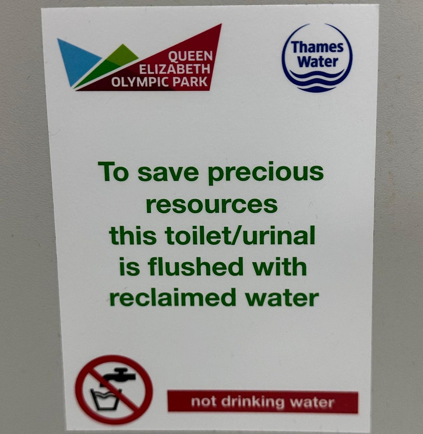 A sign which reads: To save precious resources this toilet/urinal is flushed with reclaimed water. Not drinking water. 