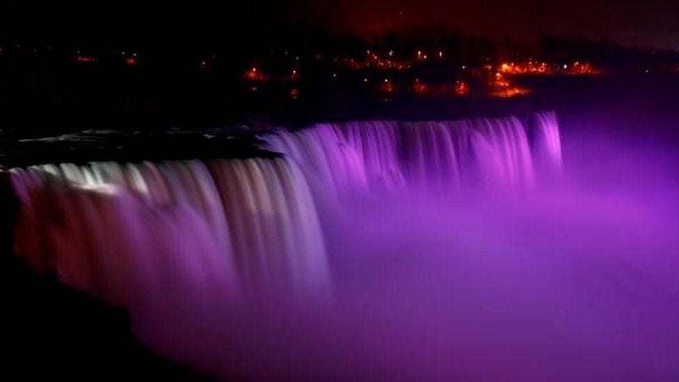 Niagara Falls lit with purple lights at night