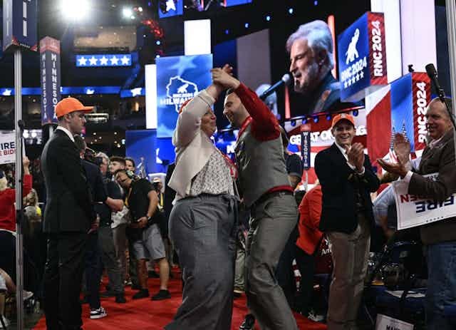 A couple dances on a red carpet.