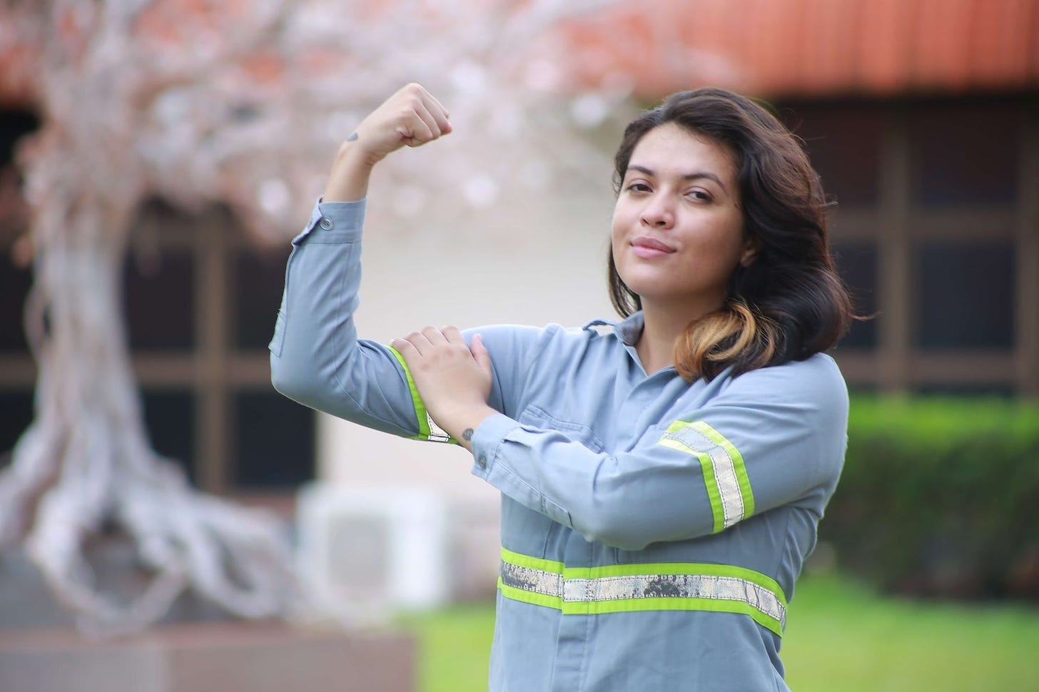 Garota de cabelos longos, com uniforme da Hydro. Ela flexiona o braço para mostrar sua força como no cartaz "We can do it!".